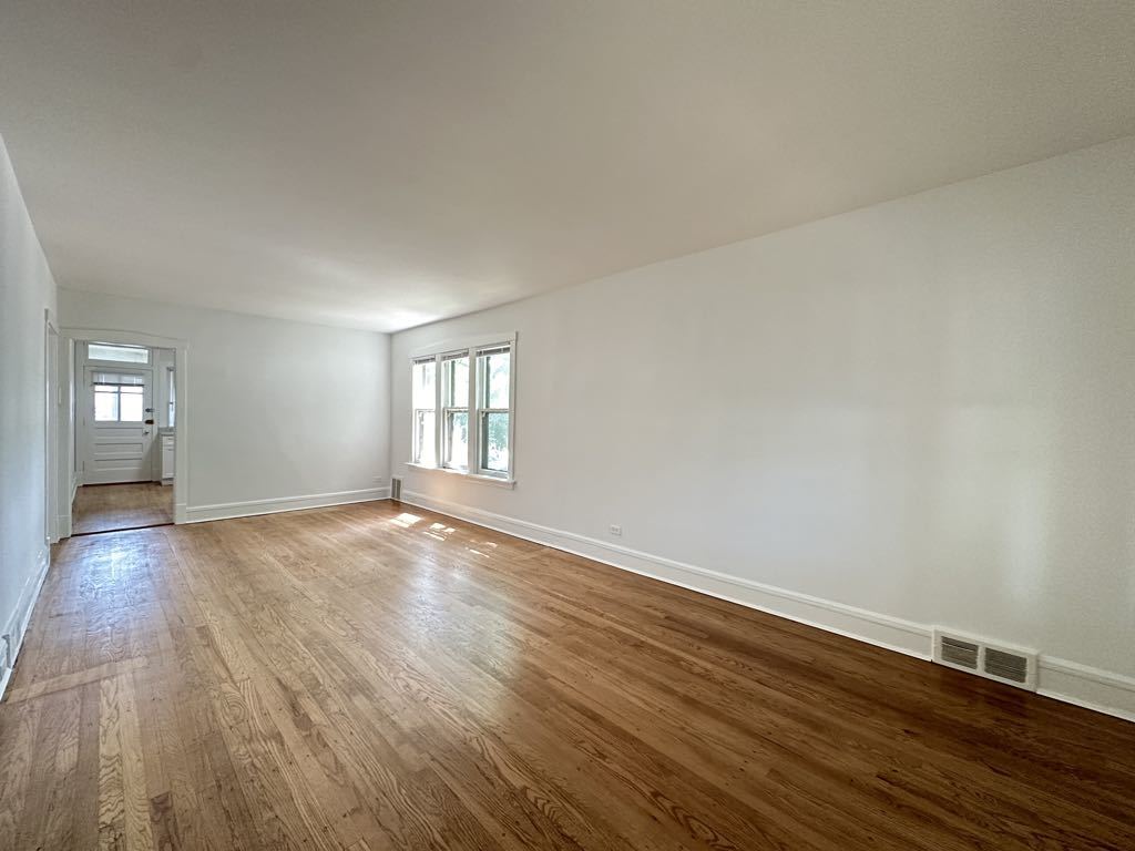 5701 North Keystone Avenue, Unit 1 Chicago, IL 60646 - Photo 11 of 20 an empty room with wooden floor and windows