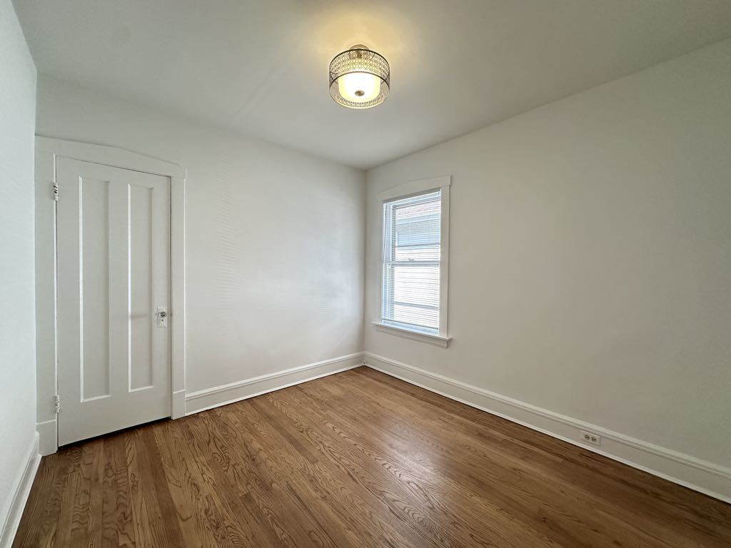 5701 North Keystone Avenue, Unit 1 Chicago, IL 60646 - Photo 12 of 20 a view of an empty room with wooden floor and a window