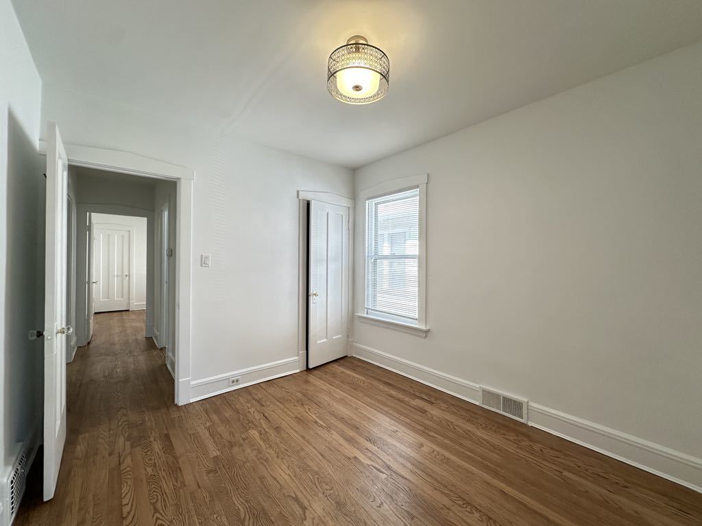 5701 North Keystone Avenue, Unit 1 Chicago, IL 60646 - Photo 16 of 20 a view of an empty room with wooden floor and a window