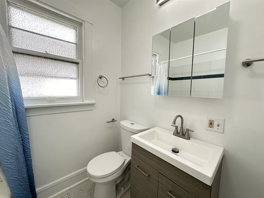 5701 North Keystone Avenue, Unit 1 Chicago, IL 60646 - Photo 19 of 20 a bathroom with a sink a toilet and a mirror