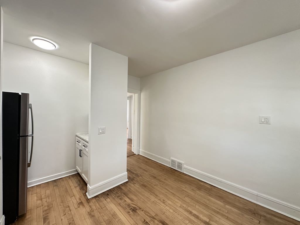 5701 North Keystone Avenue, Unit 1 Chicago, IL 60646 - Photo 7 of 20 an empty room with wooden floor and a refrigerator