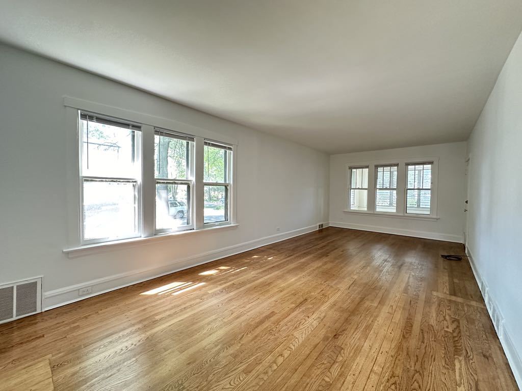 5701 North Keystone Avenue, Unit 1 Chicago, IL 60646 - Photo 8 of 20 an empty room with wooden floor and windows