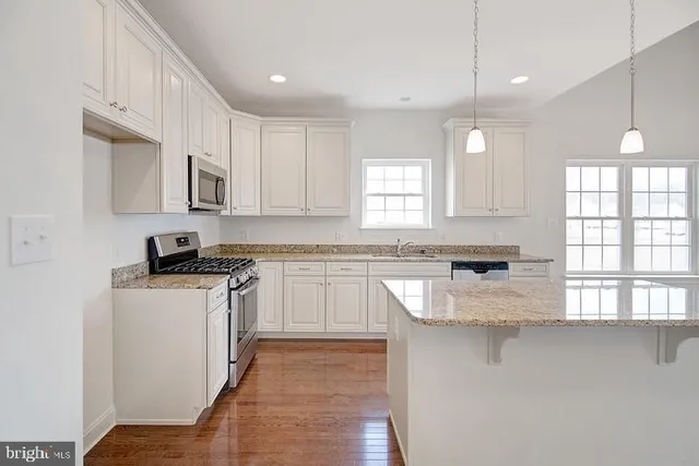 a open kitchen with window and wooden floor