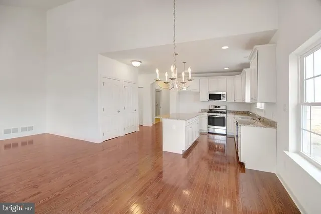 a large kitchen with granite countertop a sink a counter space appliances and cabinets