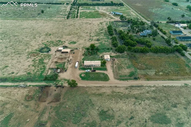 an aerial view of residential houses with outdoor space and trees