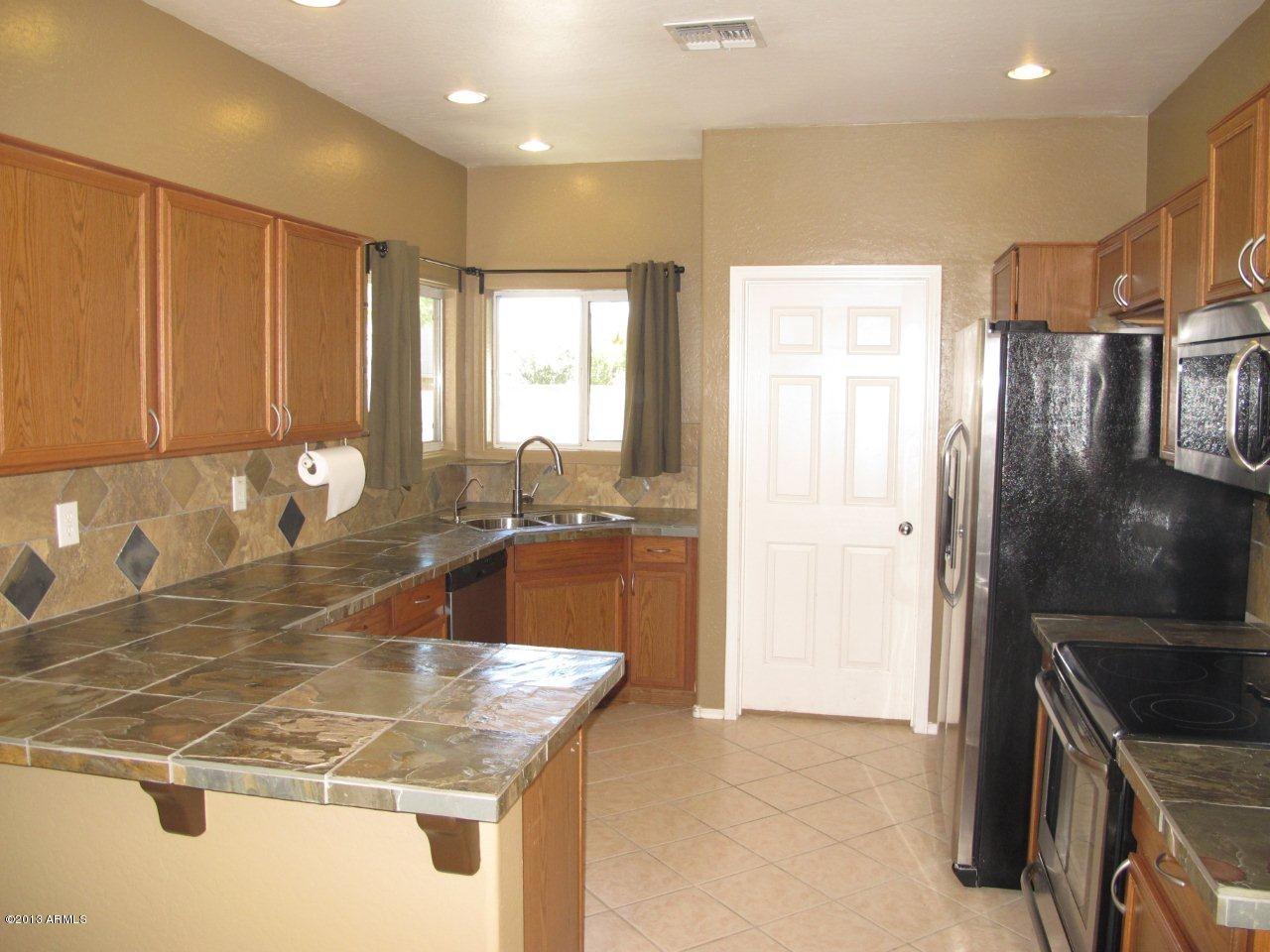1890 South Rome Street Gilbert, AZ 85295 - Photo 6 of 18 a kitchen with kitchen island a sink stove and refrigerator