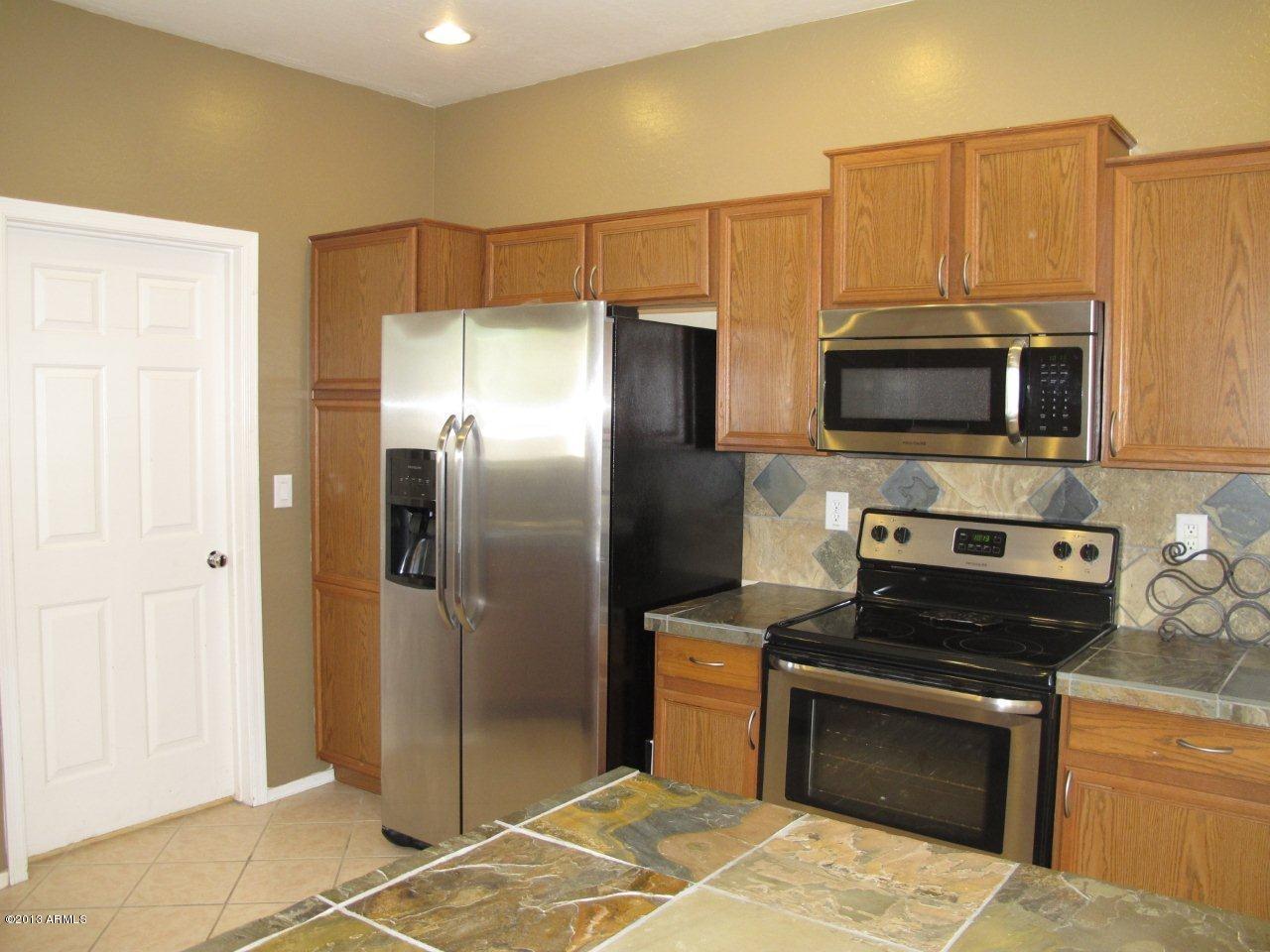 1890 South Rome Street Gilbert, AZ 85295 - Photo 7 of 18 a kitchen with stainless steel appliances granite countertop a refrigerator stove and microwave