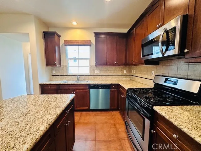 a kitchen with stainless steel appliances granite countertop a stove sink and cabinets