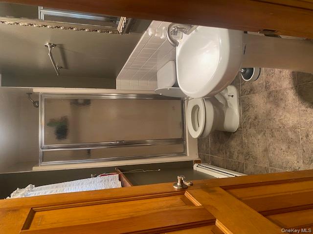 52 Woodland Road Highland Mills, NY 10930 - Photo 39 of 47 Full bath featuring a shower stall, a baseboard radiator, dark tile patterned floors, and tile walls
