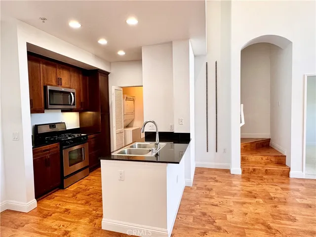 a kitchen with stainless steel appliances granite countertop a sink and a stove