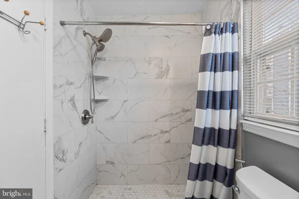 a bathroom with a shower a toilet and a window