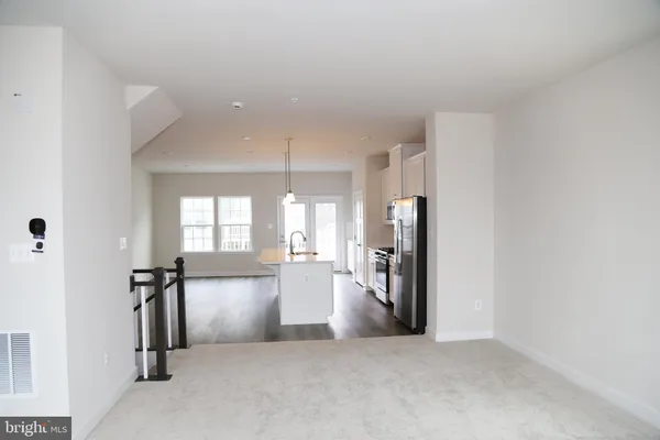 an empty room with chandelier fan and windows
