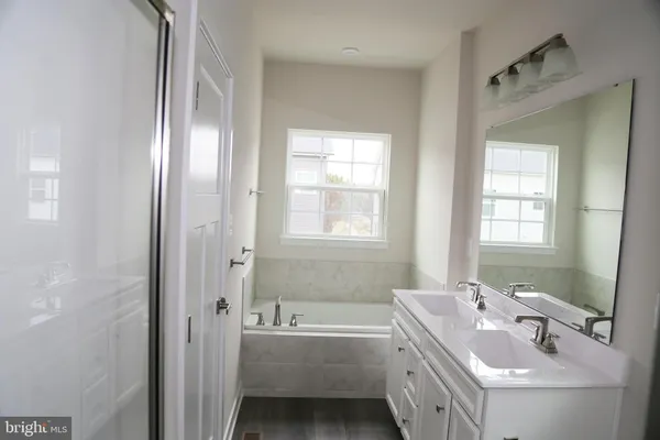a bathroom with a tub sink and mirror