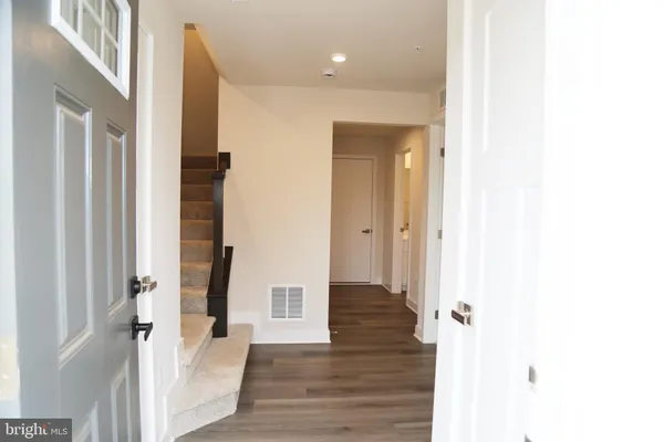 a view of a hallway with wooden floor and staircase
