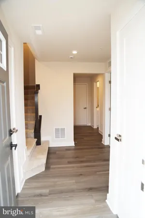 a view of a hallway with wooden floor and staircase