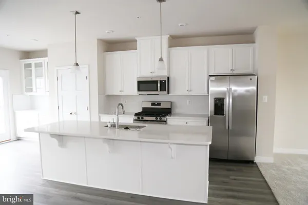 a kitchen with appliances a sink and cabinets