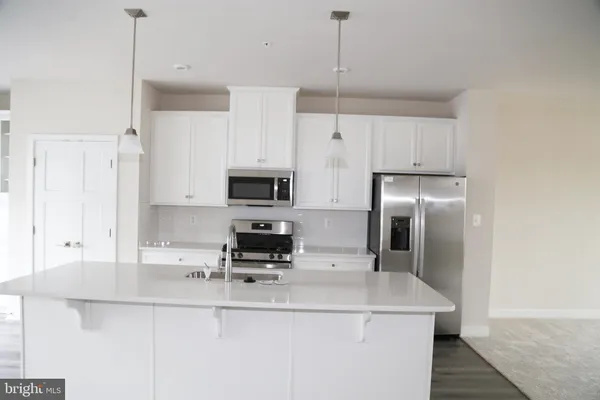 a kitchen with stainless steel appliances a sink a stove a refrigerator and cabinets