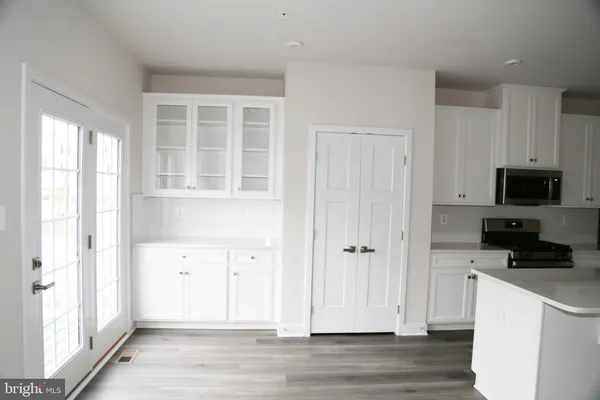 a view of a kitchen with wooden floor and electronic appliances