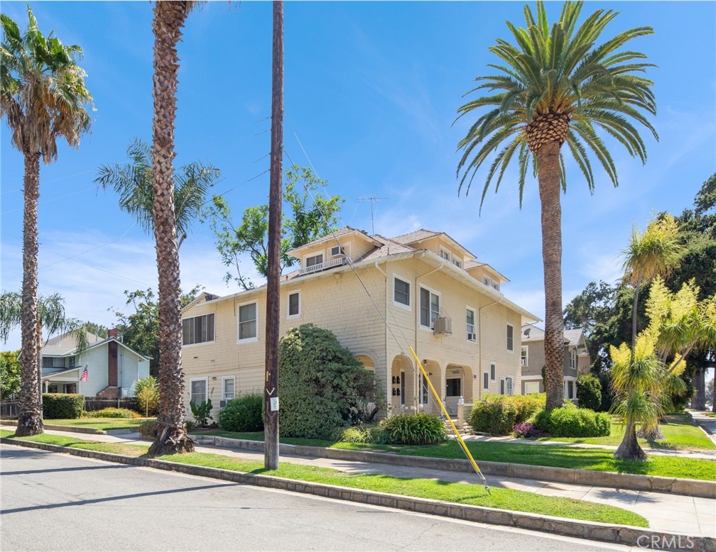 305 West Olive Avenue Redlands, CA 92373 - Photo 8 of 16 a view of a white house with a yard and palm trees