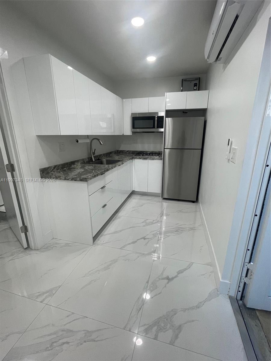 15426 Southwest 168th Terrace, Unit 2 Miami, FL 33187 - Photo 2 of 12 a kitchen with white cabinets and white appliances