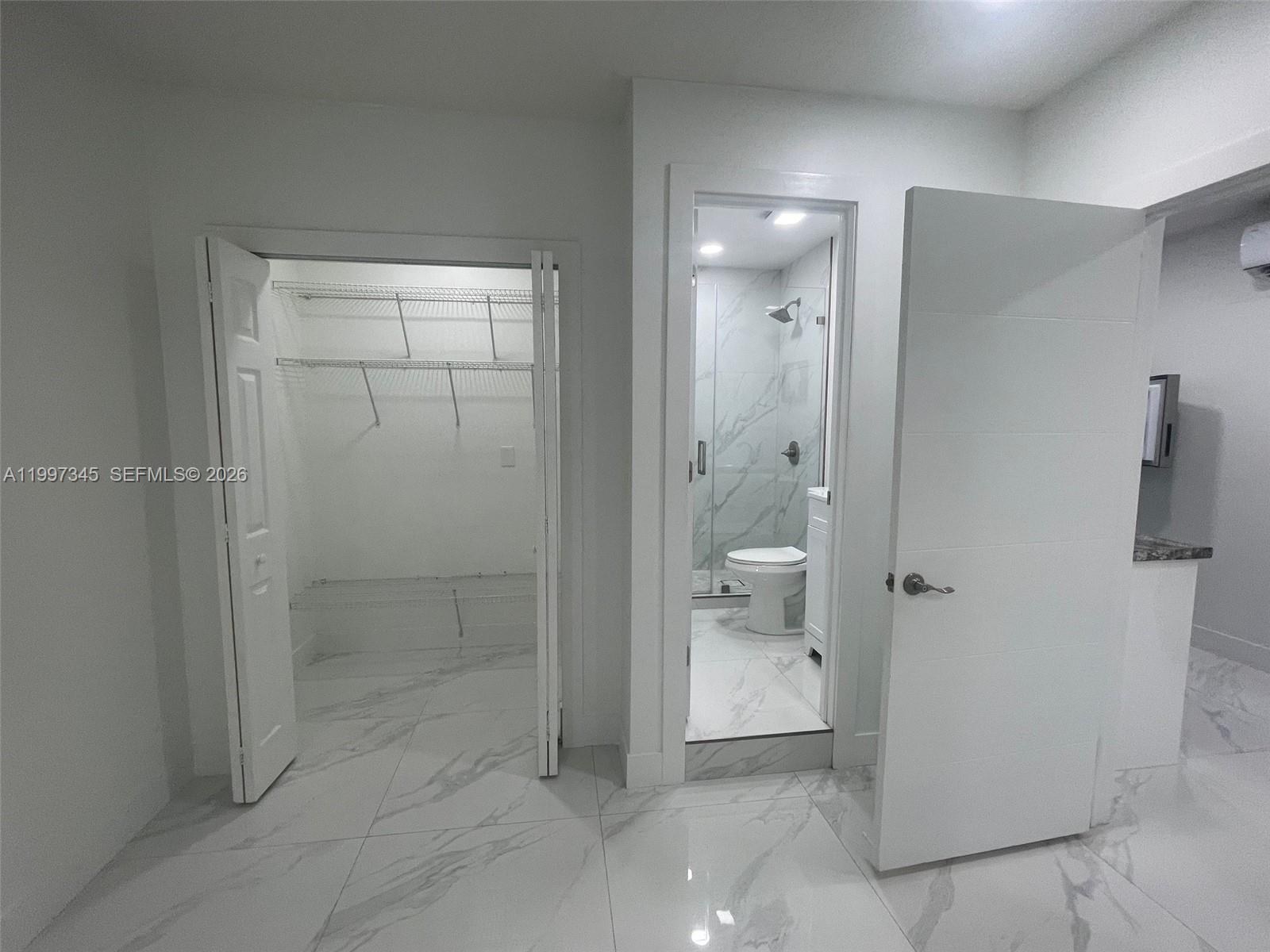 15426 Southwest 168th Terrace, Unit 2 Miami, FL 33187 - Photo 4 of 12 a bathroom with a granite countertop shower mirror and toilet