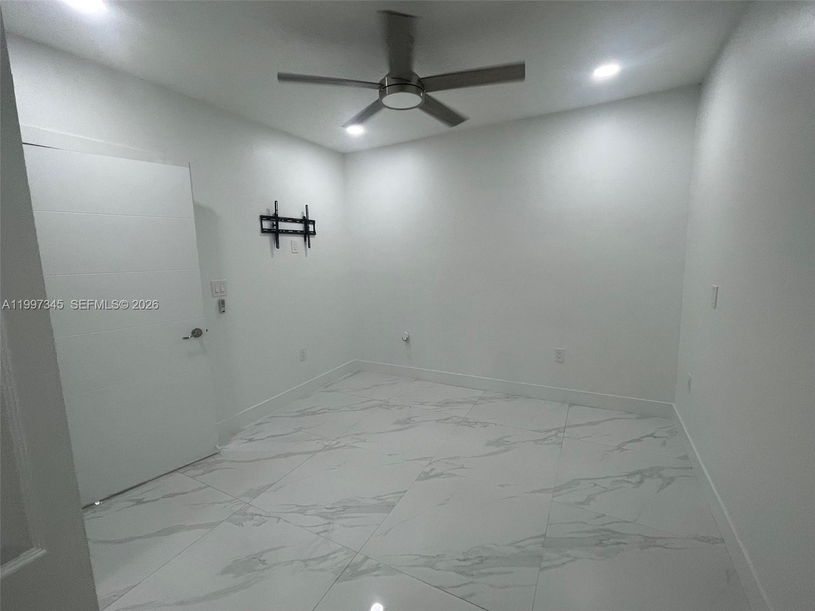 15426 Southwest 168th Terrace, Unit 2 Miami, FL 33187 - Photo 5 of 12 an empty room with a ceiling fan and shower