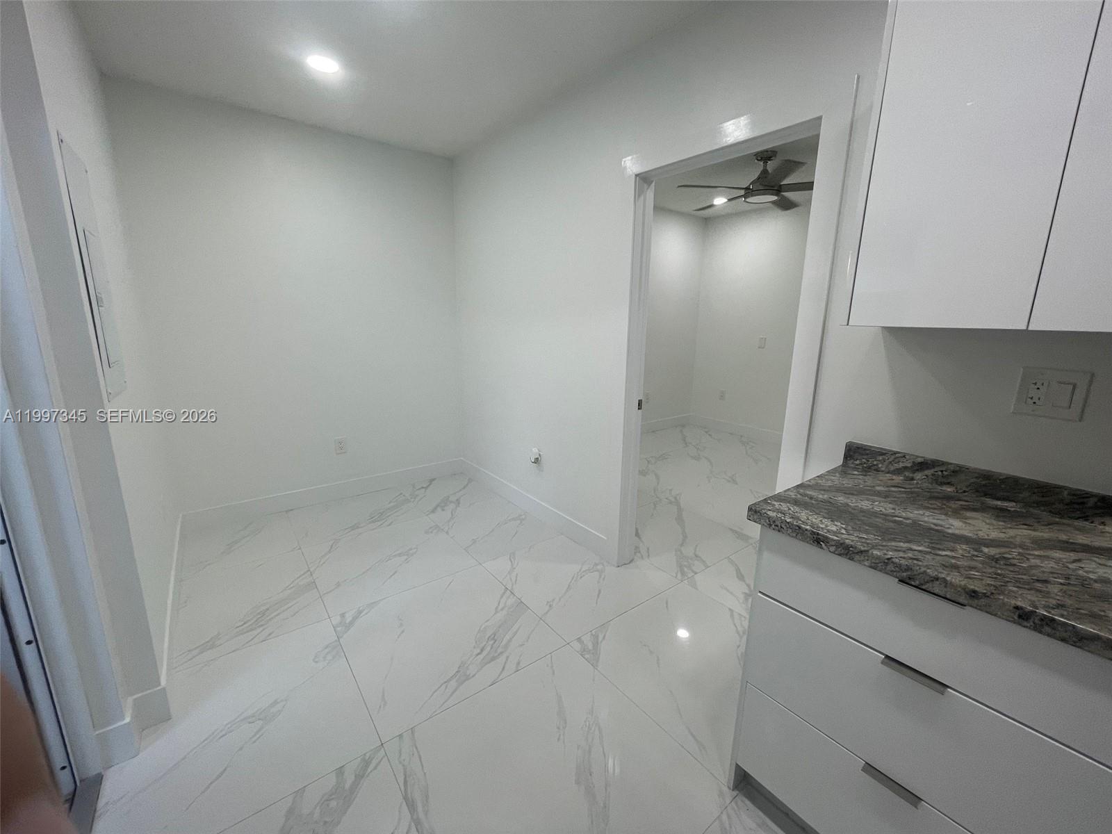 15426 Southwest 168th Terrace, Unit 2 Miami, FL 33187 - Photo 6 of 12 a bathroom with a granite countertop sink and shower