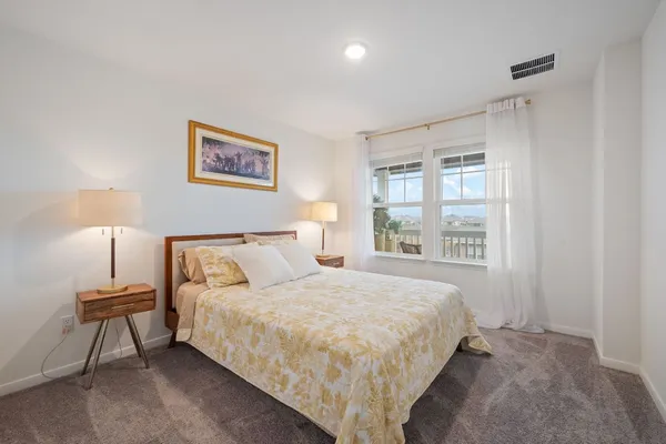 a large bed sitting in a bedroom next to a window