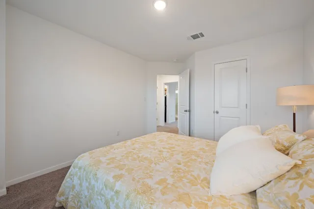 a bedroom with a bed and a lamp