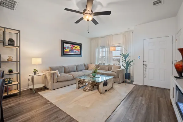a living room with furniture and a wooden floor