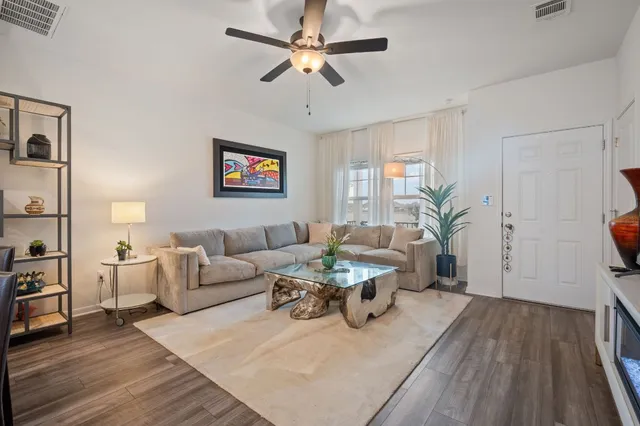 a living room with furniture and a wooden floor