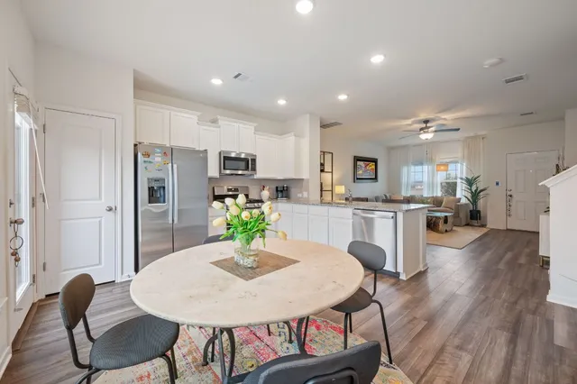 a kitchen with refrigerator and chairs
