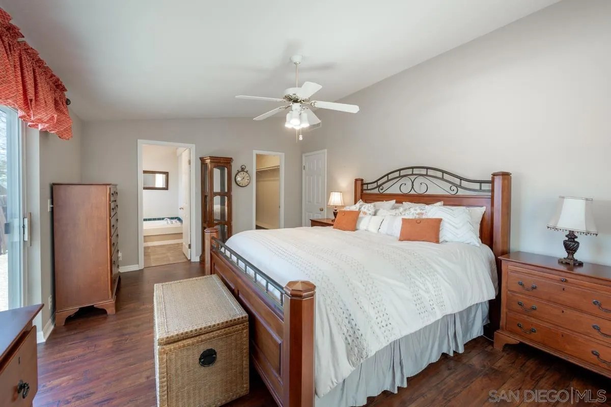 15935 Spring Oaks Road, Unit 122 El Cajon, CA 92021 - Photo 15 of 30 a bedroom with a bed and a chandelier