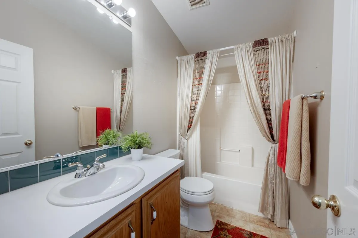15935 Spring Oaks Road, Unit 122 El Cajon, CA 92021 - Photo 23 of 30 a bathroom with a sink vanity mirror and toilet