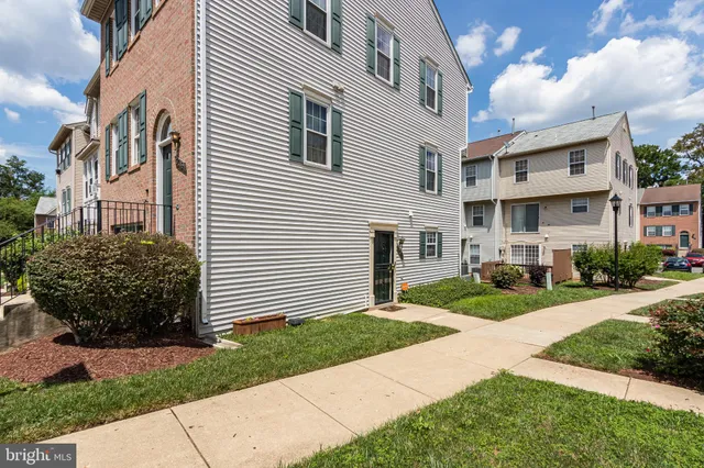 a front view of a house with a garden and plants