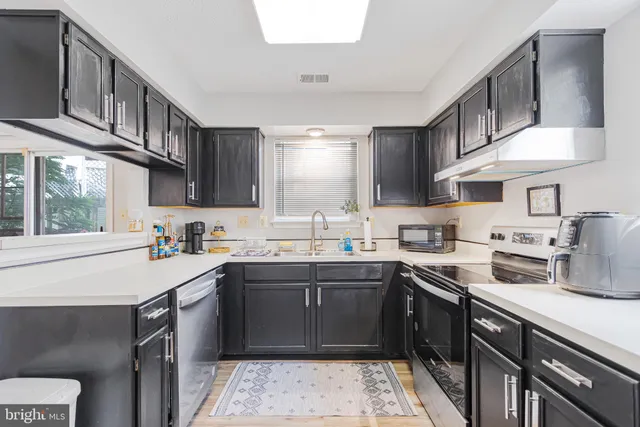 a kitchen with a sink a stove and cabinets