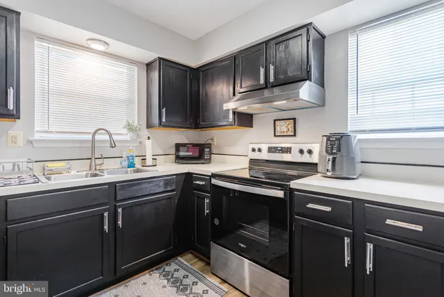 a kitchen with stainless steel appliances a sink a stove and cabinets