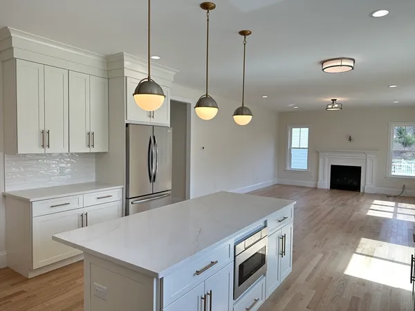 a kitchen with a stove a sink a center island and a fireplace