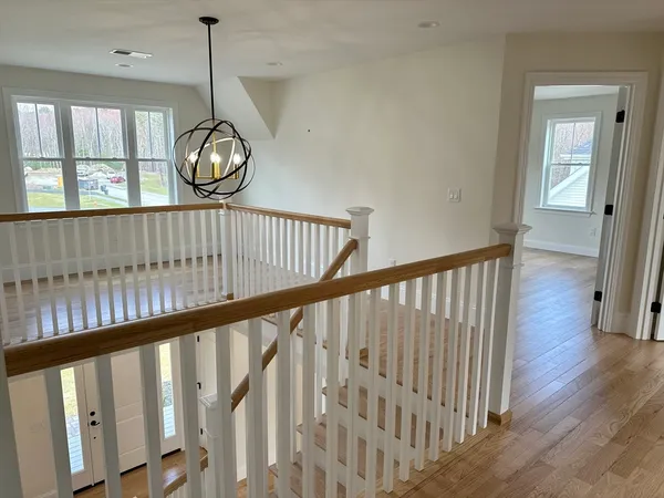 a view of staircase with railing and wooden floor