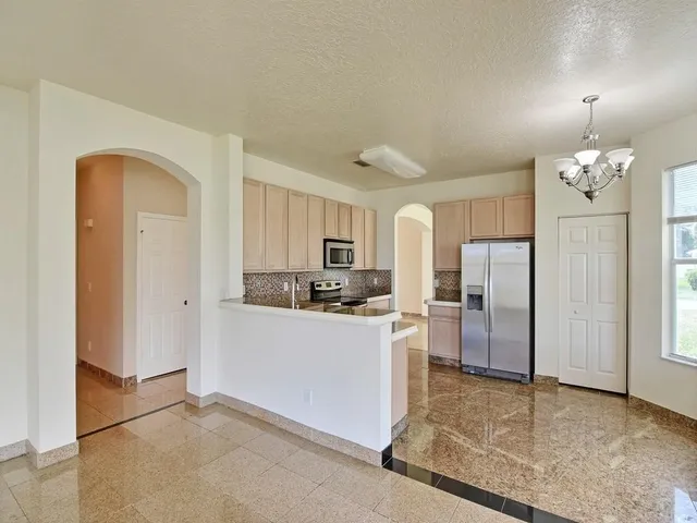 a kitchen with stainless steel appliances granite countertop a refrigerator and a stove top oven