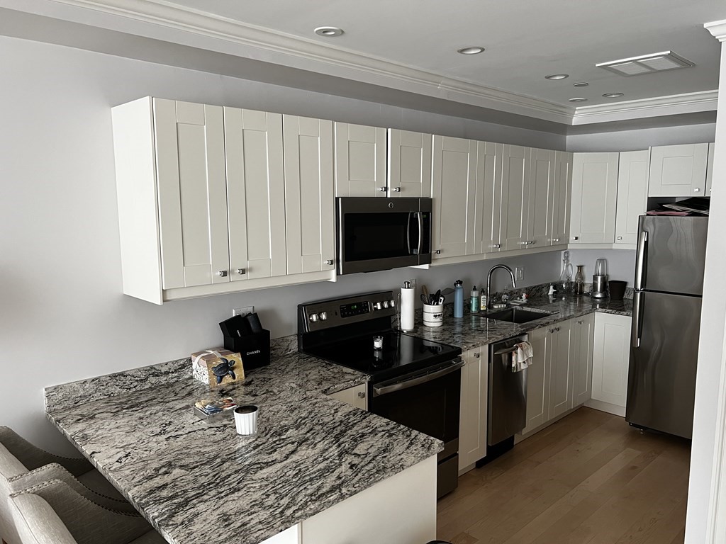296 Beacon Street, Unit 7 Boston, MA 02116 - Photo 14 of 21 a kitchen with stainless steel appliances granite countertop a sink stove and refrigerator