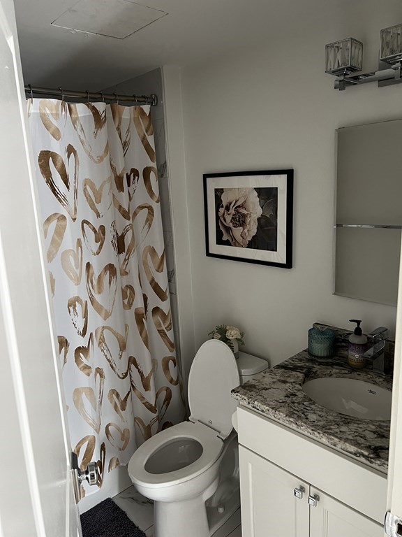 296 Beacon Street, Unit 7 Boston, MA 02116 - Photo 16 of 21 a bathroom with a granite countertop toilet sink and mirror