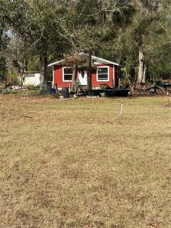 a front view of house with yard and trees around