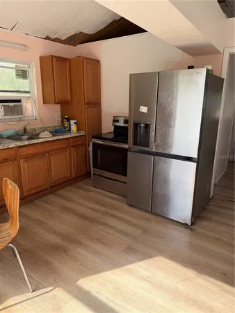 a kitchen with stainless steel appliances granite countertop a refrigerator sink and wooden cabinets
