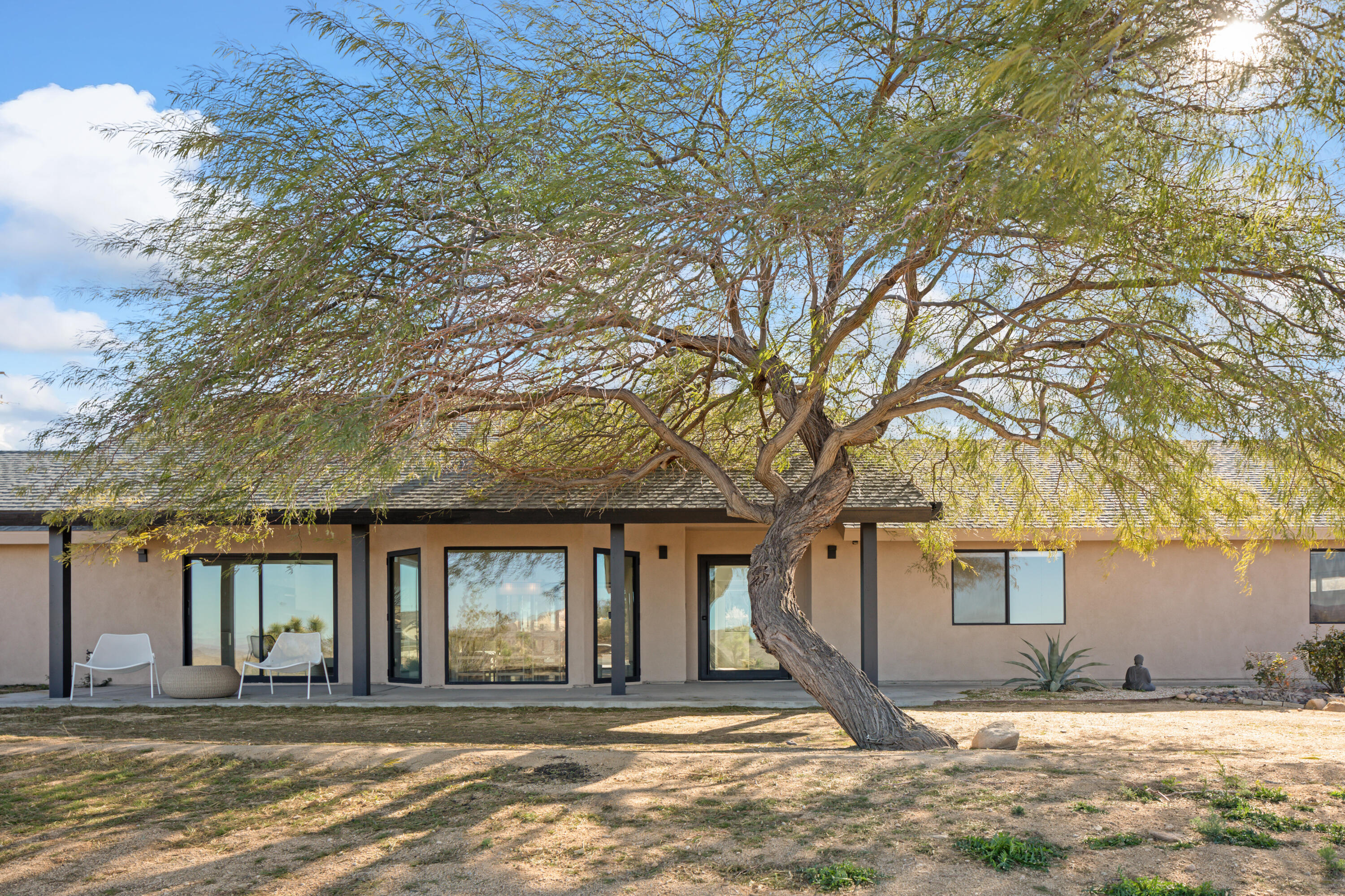 60633 Pueblo Trail Joshua Tree, CA 92252 - Photo 15 of 65 a front view of a house with a yard and garage