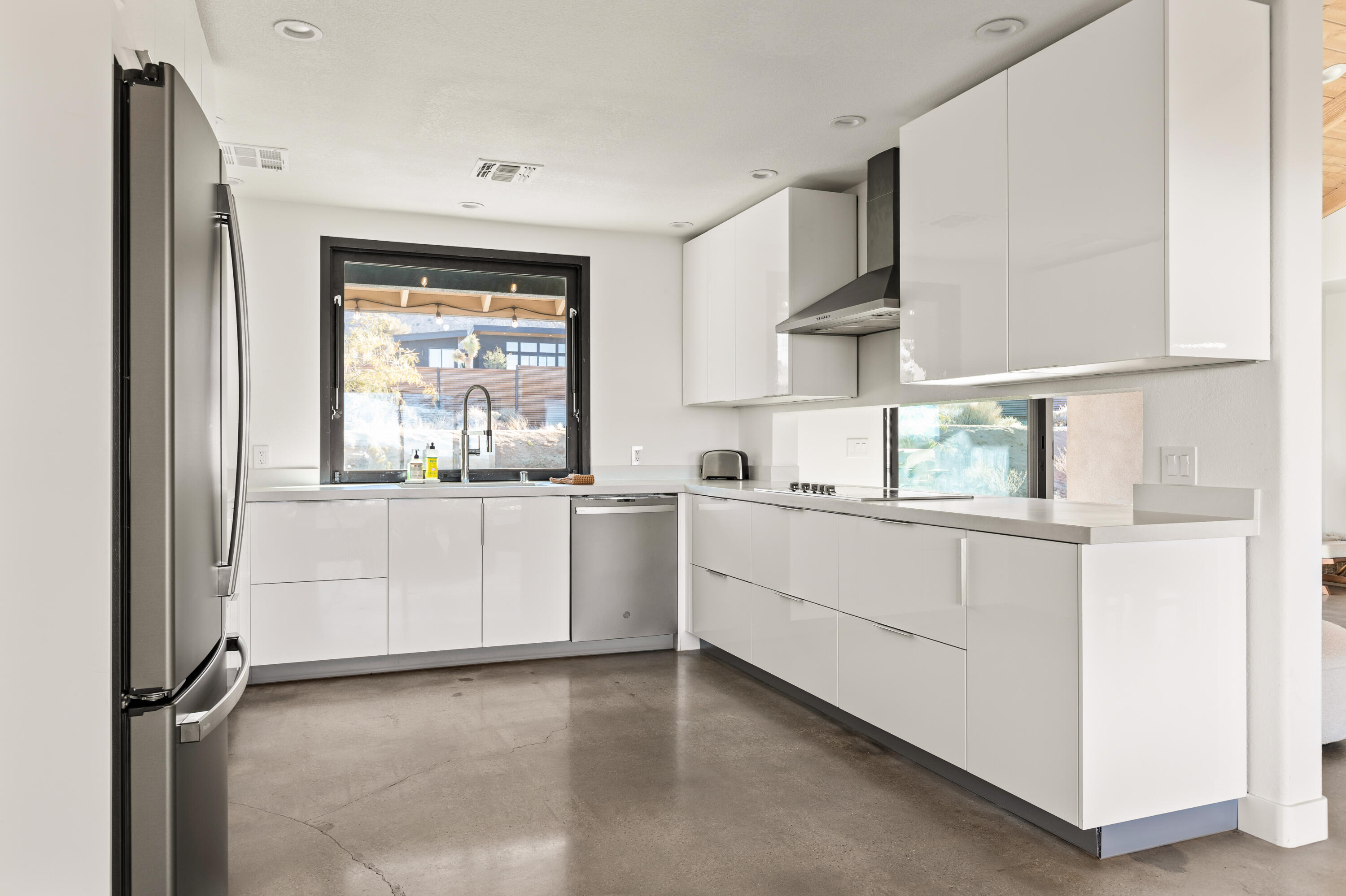 60633 Pueblo Trail Joshua Tree, CA 92252 - Photo 24 of 65 a kitchen with white cabinets and white appliances