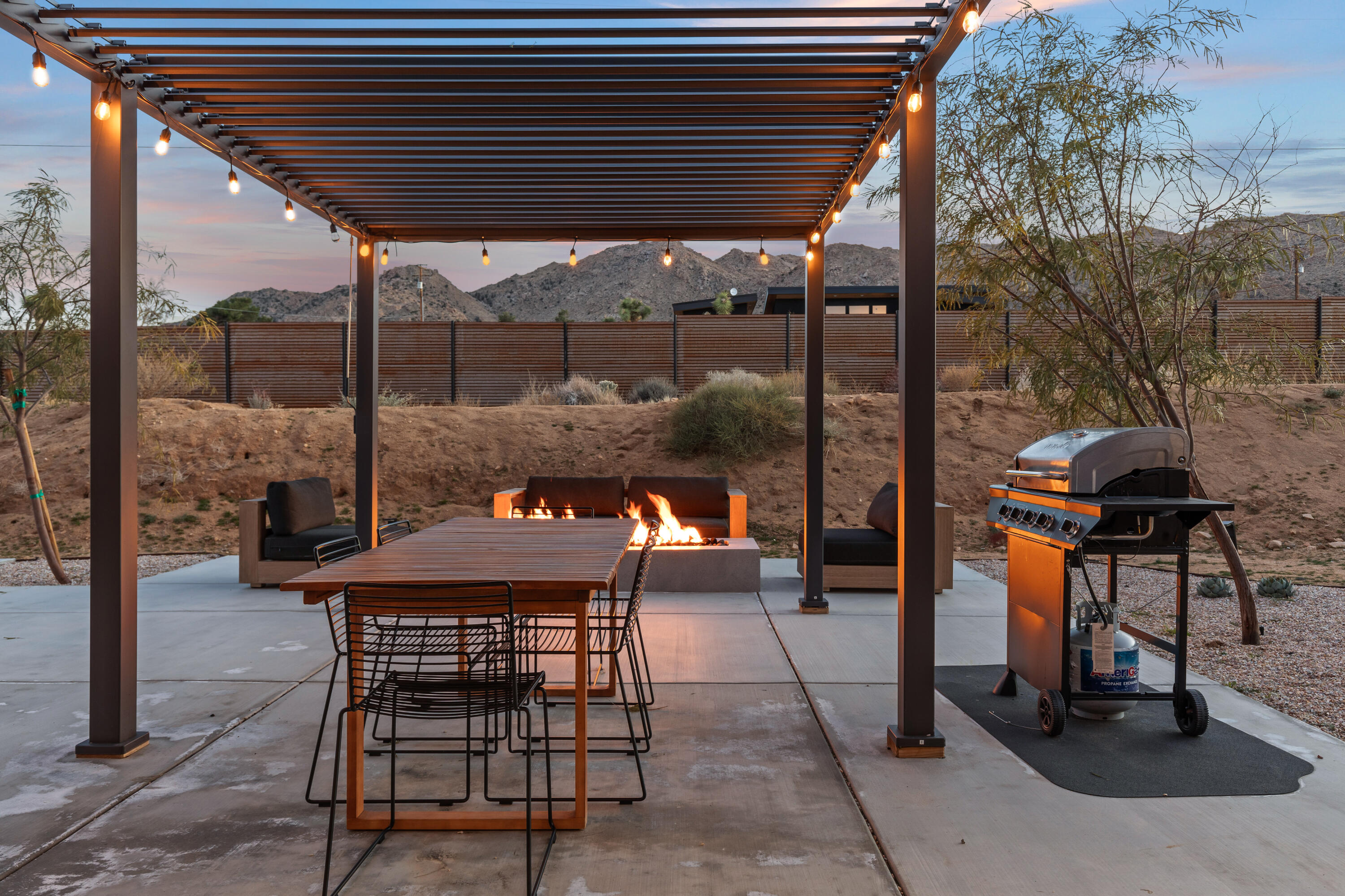 60633 Pueblo Trail Joshua Tree, CA 92252 - Photo 4 of 65 a patio with a table and chairs and potted plants