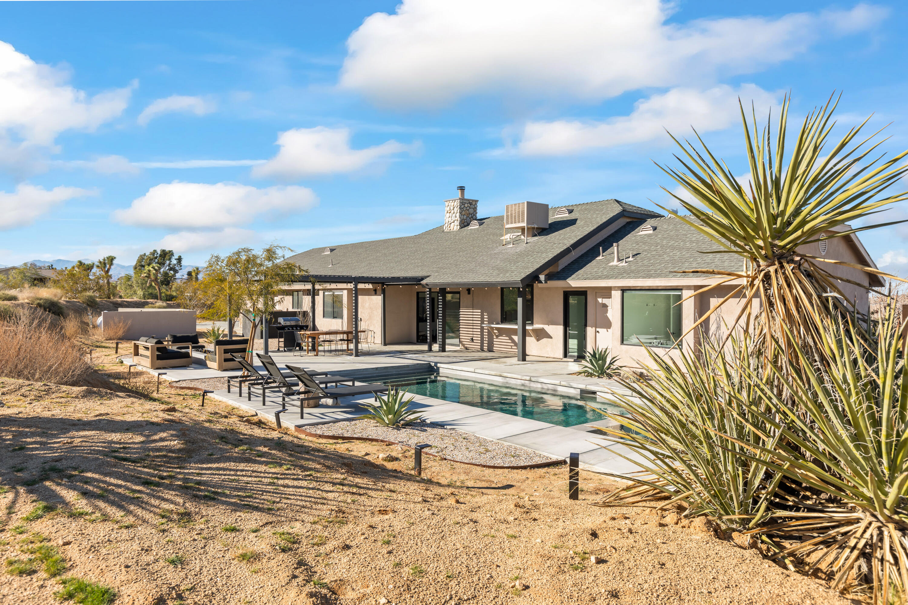 60633 Pueblo Trail Joshua Tree, CA 92252 - Photo 53 of 65 a view of a house with swimming pool and sitting area