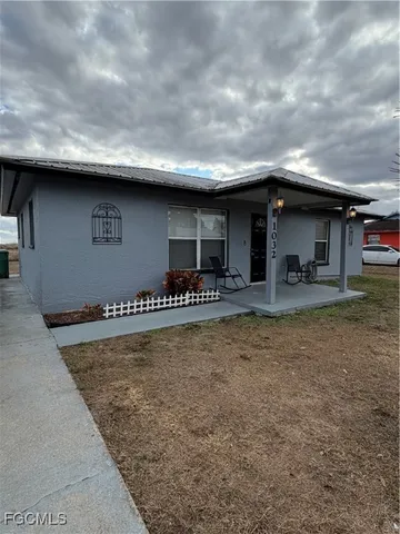 a backyard of a house with table and chairs