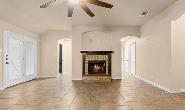 an empty room with fireplace and fan